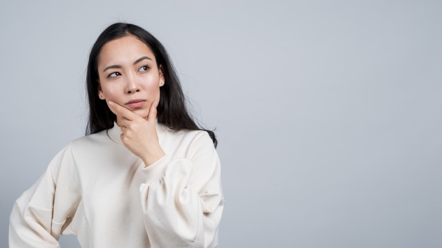 首を傾げて悩んでいる女性